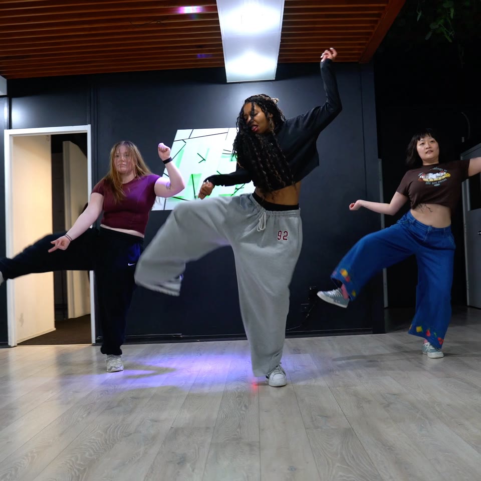 Three dancers moving together during a HIT class